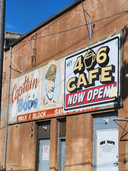 Signage for Captain Bou's and 406 Cafe, featuring a captain's portrait and "NOW OPEN" announcement.